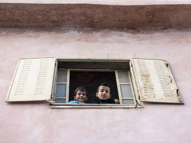 Zwei Kinder schauen aus einem Fenster in Bethlehem