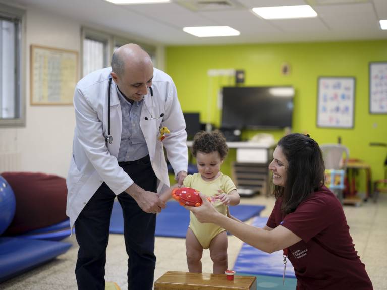 Dr. Nader und eine Physiotherapeutin helfen einem Patienten
