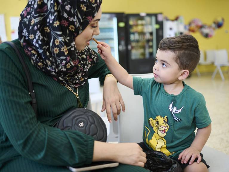 Gemeinsam die Wartezeit verkürzen: Aser und seine Mama im Caritas Baby Hospital Gemeinsam die Wartezeit verkürzen: Aser teilt mit seiner Mutter etwas Süßes im Wartebereich des Caritas Baby Hospitals. © Meinrad Schade/KHB