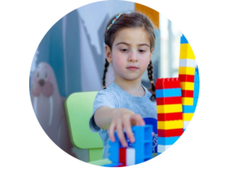 Spenden für Kinder in Palästina - das Bild zeigt ein Mädchen, das mit Bauklötzen im Caritas Baby Hospital spielt, was den Bau der Kinderchirurgie verdeutlichen soll