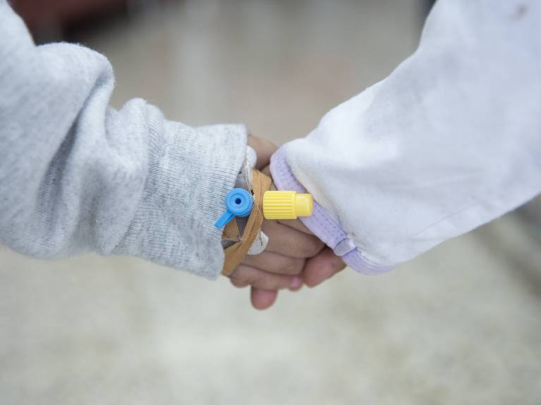 Spenden Kinderhilfe Bethlehem Zwei kleine Hände mit Infusionsnadeln halten sich