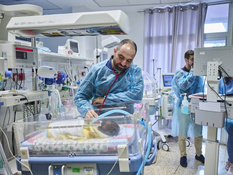 Ein Krankenpfleger behandelt ein krankes Kind auf der Intensivstation