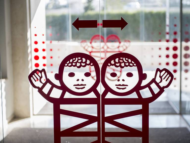 Ein Bild der Eingangstür im Caritas Baby Hospital mit dem Logo der Wickelbabys