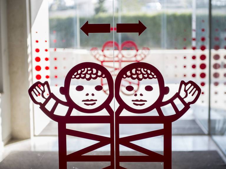Ein Bild der Eingangstür im Caritas Baby Hospital mit dem Logo der Wickelbabys
